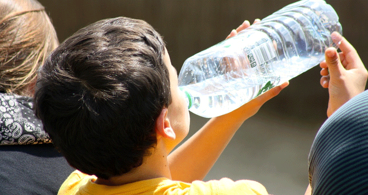 Kind trinkt Wasser aus Flasche