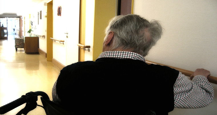 Altenpflege im Pflegeheim mit Mann im Rollstuhl